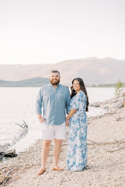 A couple smiles while walking in a shallow alpine lake as guided by their Breckenridge Couples Photographer