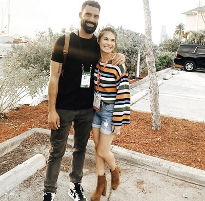 Couple stands close together for photo outside event