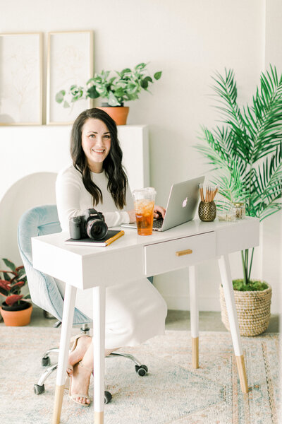 Portrait of Katie Jane Photography sitting at a desk