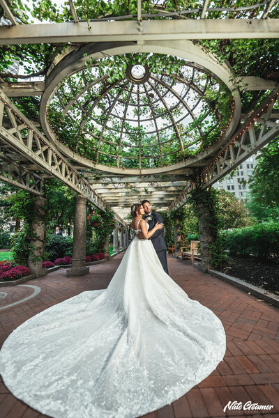 A groom sitting on a sofa while his bride stands next to him at Winvian Farms in Morris, Ct.