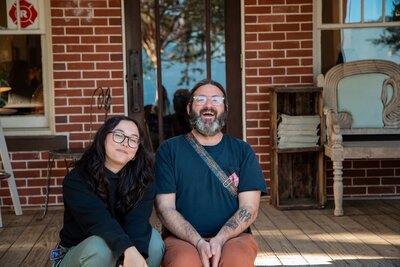 Two musicians sit on the front porch of Hillcrest Coffee