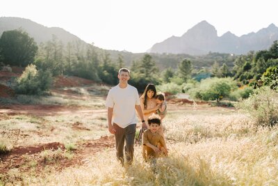 Parents with two boys pose in a field in Sedona Arizona