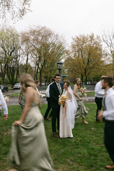 wedding party gathering outdoors during a backyard wedding celebration in Kansas surrounded by soft spring color


