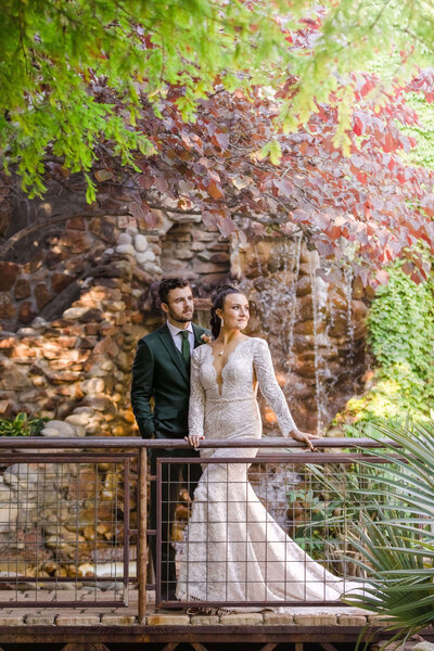 The bride and groom stand together in a picturesque garden radiating love and joy.