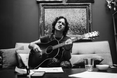 Singer playing guitar while writing song