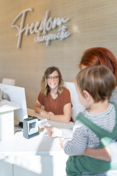 Woman holding baby at front desk