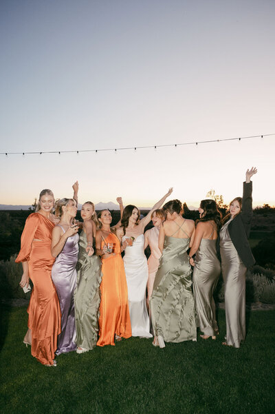 The bride and her bridesmaids twirl and laugh together on the dance floor, lost in a moment of pure celebration and sisterhood.