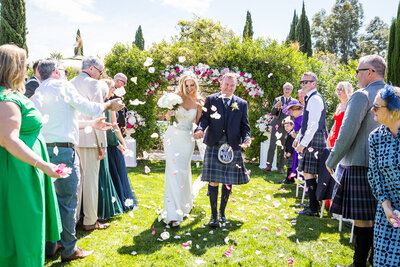 Bride and groom walking back up the aisle being showered with confetti at their Marbella wedding