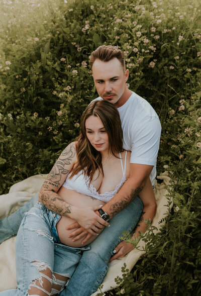 Expecting mother and father in an outdoor maternity photoshoot in the Twin Cities, lovingly embracing while capturing the joy of parenthood by Shannon Kathleen Photography.