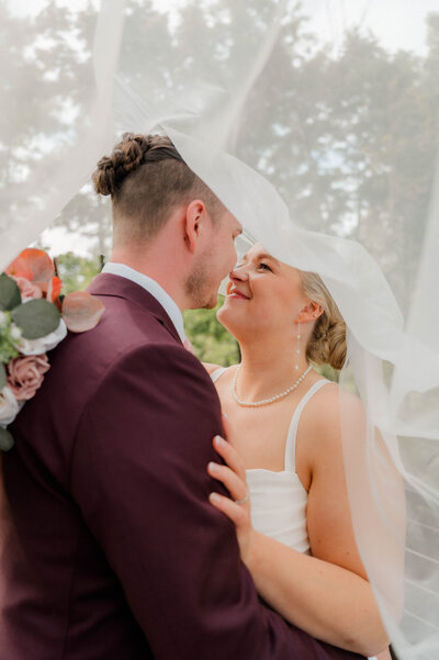 Groom and Bride pose for the camera holding one another and smiling.