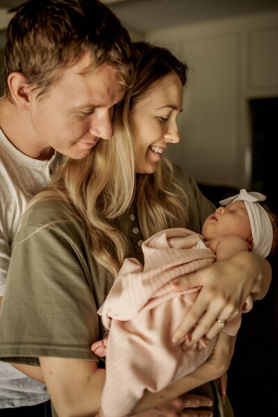 toddler hold newborn sibling at a home session in Lewisville Texas