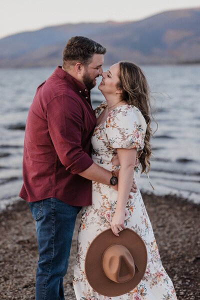 Denver Engagement Photographer, couple embraces during lakeside mountain engagement photos.