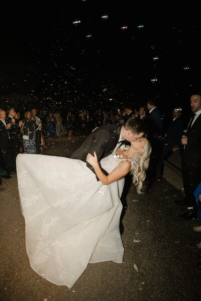 Couple kissing with bubbles being blown in the background