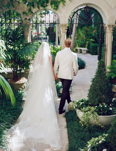 Bride and groom walking hand in hand at their elegant private club wedding in Palm Beach, captured in timeless fine art style.