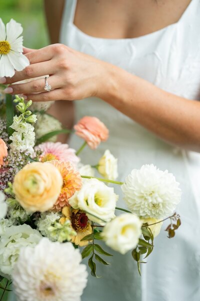 Bride touches her flowers at her luxury wedding in Aspen. 