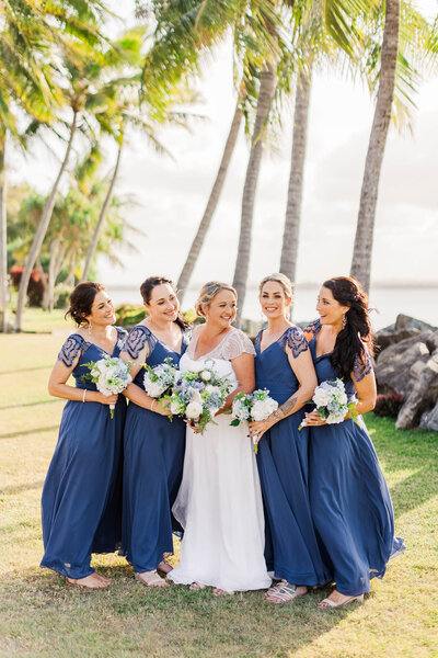 bride laughs with her bridesmaids during the bridal party photos on mackay beach.