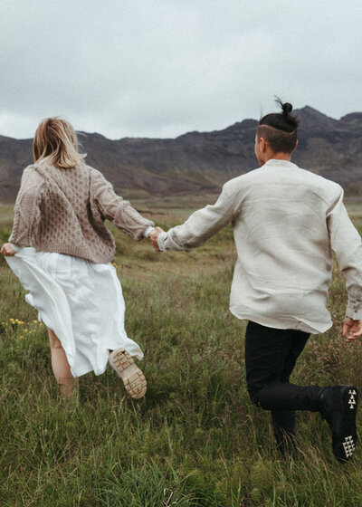 couple holding hands walking the mountains of Iceland