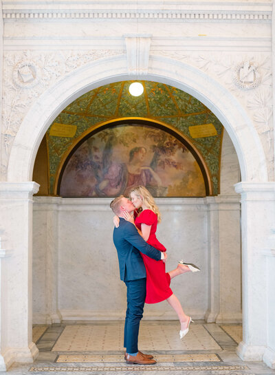 Couple lifting for a kiss at the Library of Congress in Washington, DC. Taken by DC Wedding Photographer Bethany Aubre Photography.