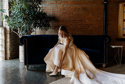 Chicago bride in elegant gown slips into heels preparing for her ceremony.