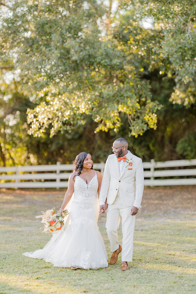 Bride and groom kiss during their Charleston wedding ceremony next to cross with flowers