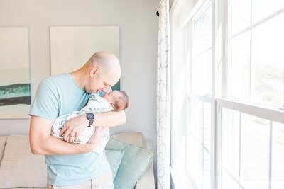 Sisters hdad holds baby during in home newborn photo session with Sara Sniderman Photography  in Sherborn Massachusetts
