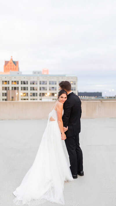 Milwaukee wedding photos of couple on rooftop at sunset over looking Milwaukee