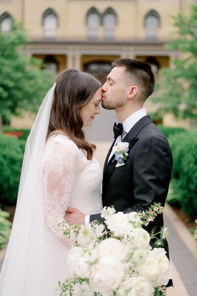 groom kissing bride on the forehead