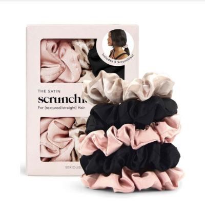 A box of Kitsch satin scrunchies in soft blush, cream, and black shades, with a product photo on the packaging and scrunchies stacked in front. Designed to be gentle on hair and prevent breakage.