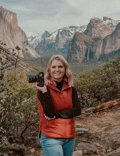 yosemite elopement photographer holding camera with tunnel view in the background