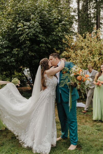 bride and groom holding hands while their bridal party is standing around them