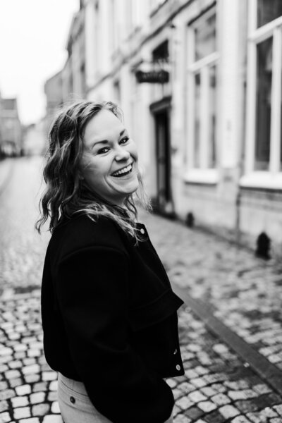 Susan limburgse fotograaf Puur Susan handen door haren kijkt naar rechts zwartwit