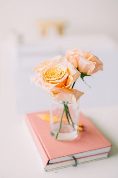 a flower vase sitting on top of a stack of notebooks