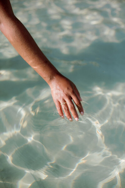 hand touching the water surface