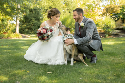 Bride her groom enjoy a special moment with their pup on their wedding day in Solon, Ohio. Photographed by Aaron Aldhizer
