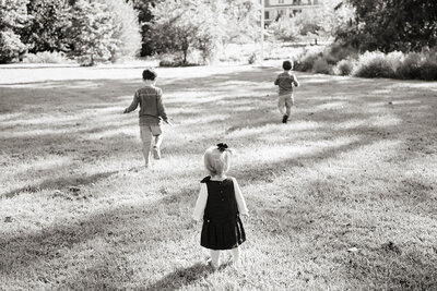 Three small kids running in a park 