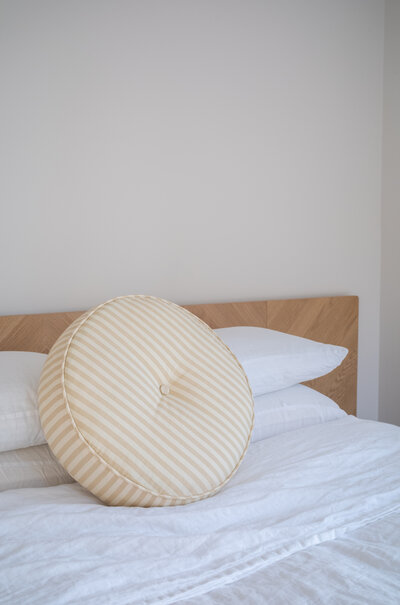 Custom round throw pillow with vintage stripe fabric.