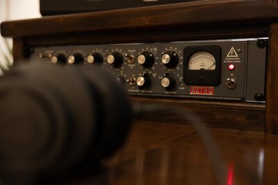 Close up photo of preamp and headphone on a desk.
