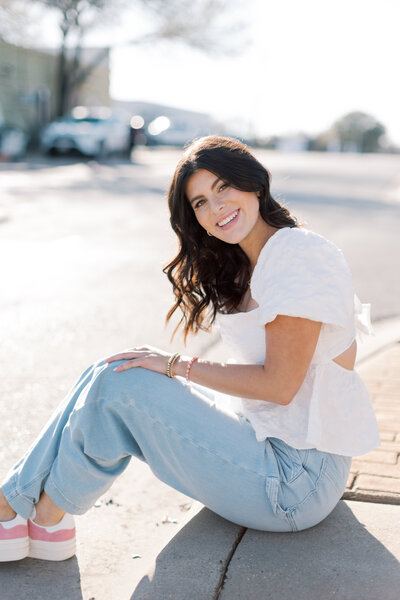 Casual senior portrait pose of girl sitting in sunshine in Southern California