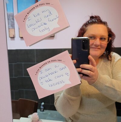Samantha Laycock in front of a mirror with positive Post-It Notes.