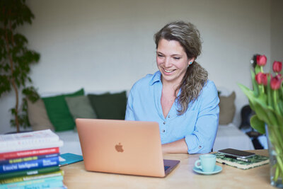 Sarka, a life coach from Brno,  looking happily at her laptop