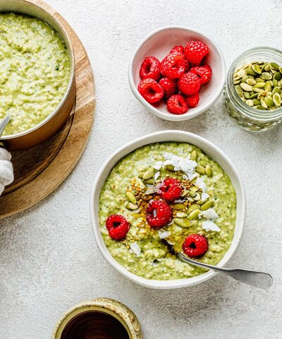 Menopause-friendly matcha oats topped with raspberries, pumpkin seeds and coconut flakes – a vibrant, nutrient-rich breakfast to support hormone balance