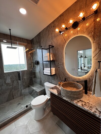 Bathroom with grey tiles on the walls and floating wooden vanity