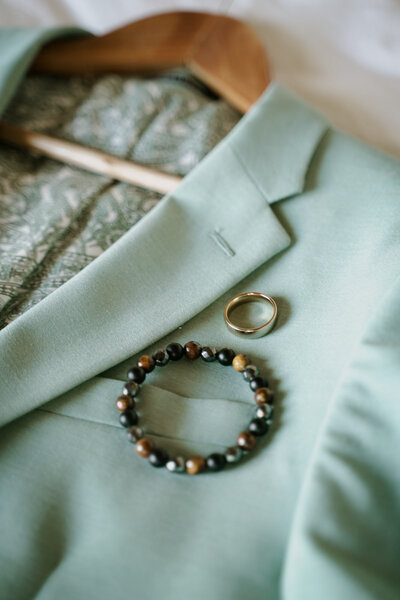 suit with beaded bracelet and gold ring