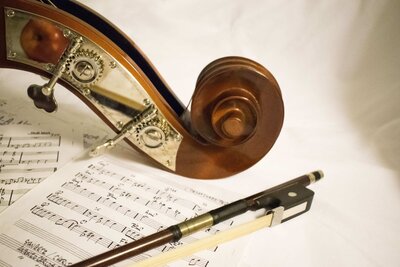 The cover photo for the article "Rethinking Pain: What if Your Technique is the Culprit?" is a violin scroll and bow.
