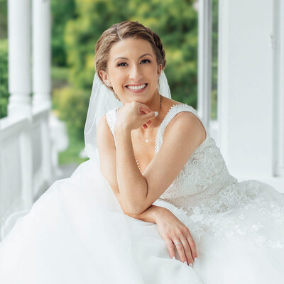 Bride posing on porch | Summer Wedding at Mountainville Manor | Mountainville, New York