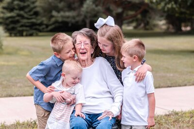 Grandmother surrounded by her four grandchildren hugging her