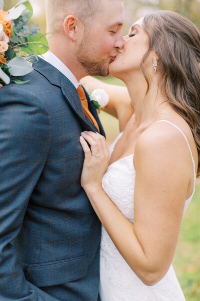 close up of bride and groom kissing at sunset