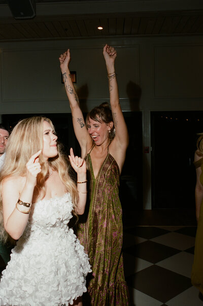 Black and white image of bride laying on the floor with her bridesmaids