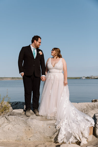 Elopement couple standing side by side and looking at each other on Lake Erie.