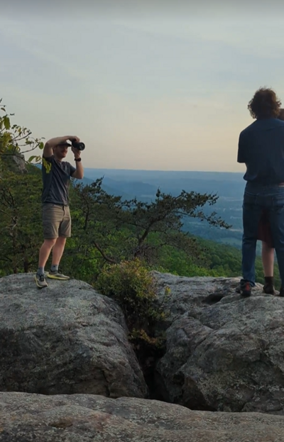 Photographer taking a photo of a couple at sunset